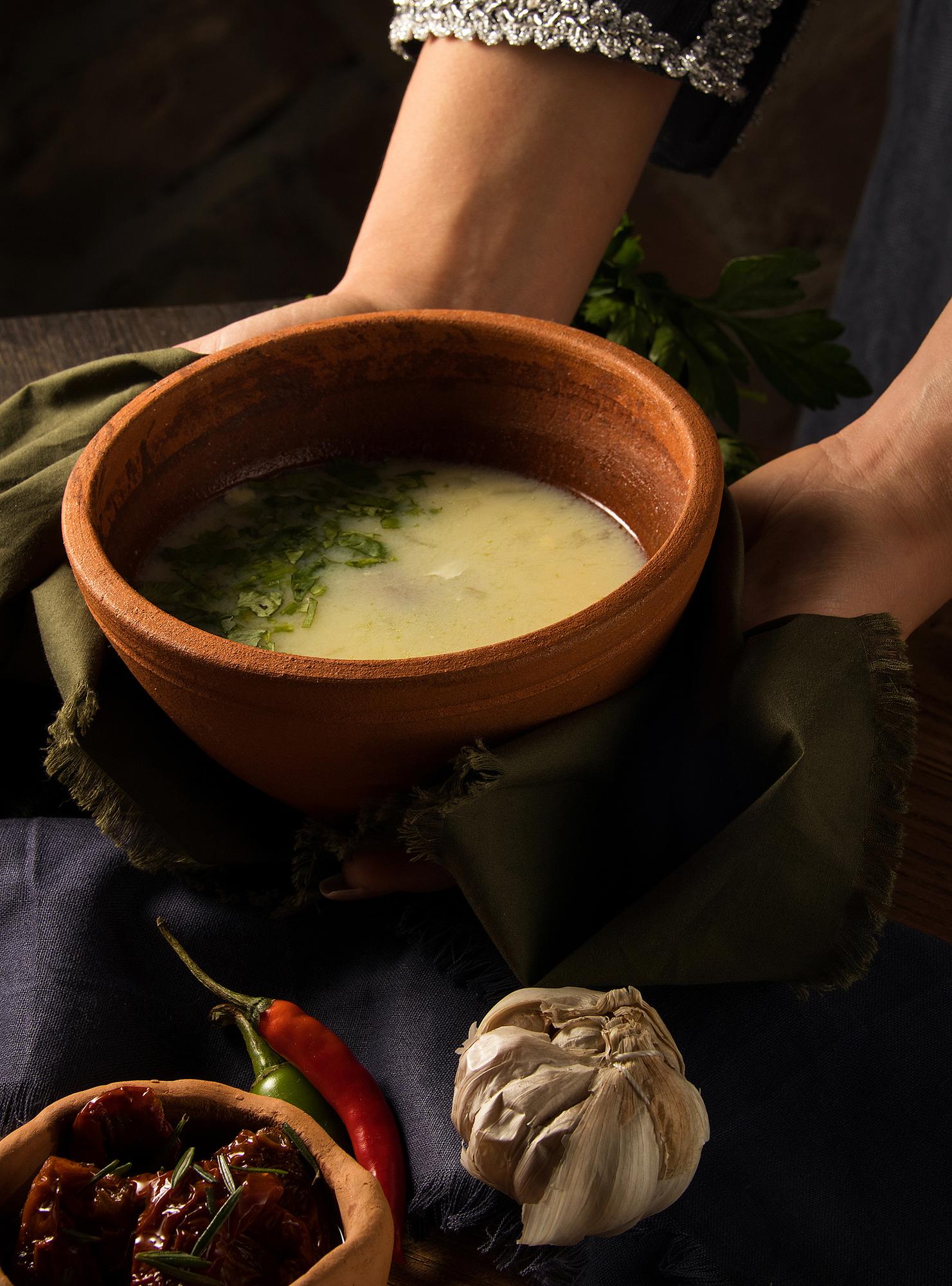 Handmade ceramic bowl with rustic soup and herbs